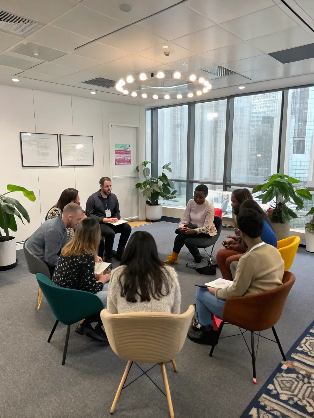 An image of a diverse group of professionals engaged in a leadership workshop, with a coach facilitating discussions, representing the Leadership Development Program.